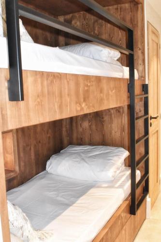 two bunk beds with white pillows on them at Apartment WABI-SABI by JAPANDI home in Megève