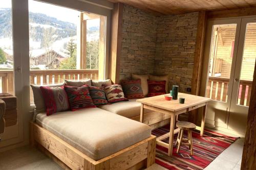 - un salon avec un canapé et une table sur une terrasse couverte dans l'établissement Apartment NAVAJO by JAPANDI home, à Megève