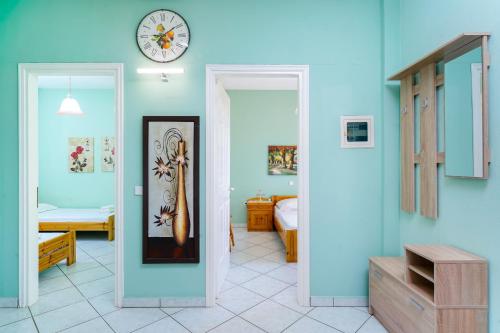 a room with blue walls and a clock on the wall at Villa Melina 2 in Koinyra