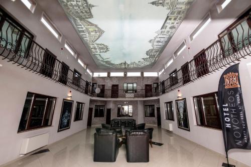 a lobby with a coffered ceiling and black furniture at Hotel Novotheos in Oradea