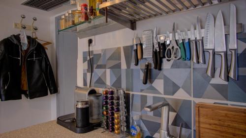 - une cuisine avec un mur avec des couteaux et des ustensiles dans l'établissement Les Tambourins Studio 19 - 3 étoiles, à Cannes