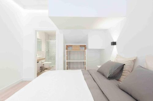 a white bedroom with a white bed and a window at LUR Apartments Getaria in Getaria
