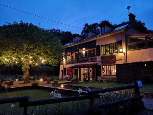una casa grande con luces en el patio por la noche en Pyrenées Emotions, Eco-responsables, Nature, Sports Aventures, en Malvézie