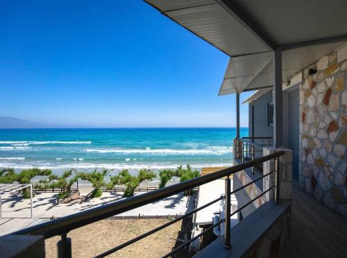 a view of the beach from the balcony of a house at Golden Dolphin Studios & Apartments in Alykes