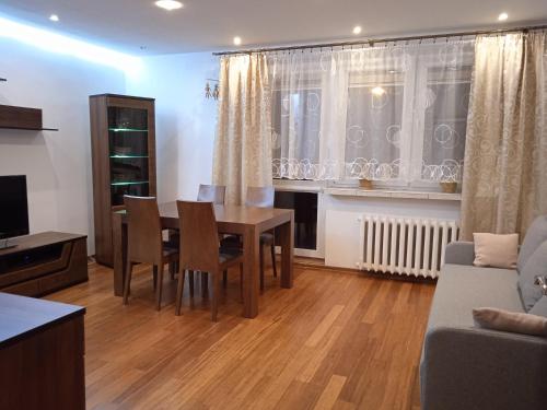 a living room with a table and chairs and a couch at Apartament Bukowa Kopa in Stronie Śląskie