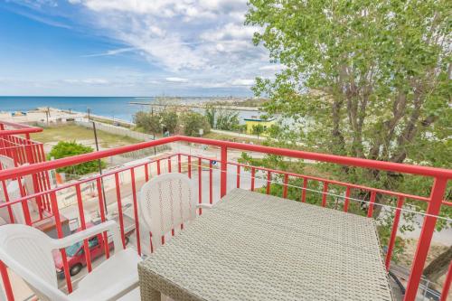 een tafel en stoelen op een balkon met uitzicht op de oceaan bij Hotel Marylise in Rimini