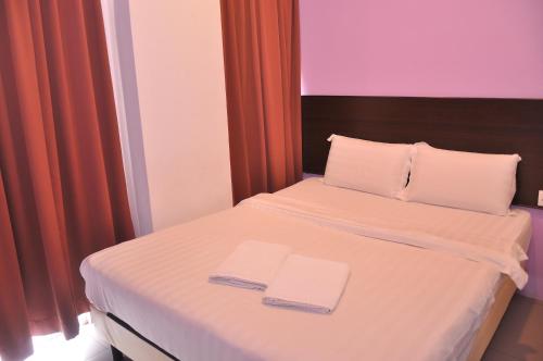 a bedroom with a bed with two towels on it at Kuching Transit Inn in Kuching