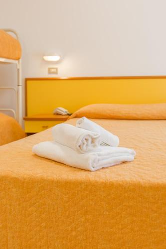 a pile of white towels sitting on top of a bed at Hotel Marylise in Rimini