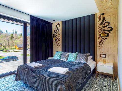 a bedroom with a bed and a large window at Aparthotel Góralski Spa 2 in Białka Tatrzanska