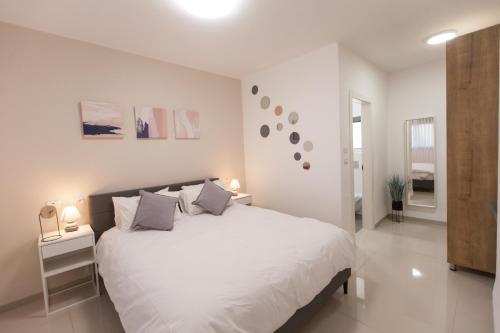a white bedroom with a large white bed with pillows at Luxury apartment of sea galilee - Kinneret in Tiberias