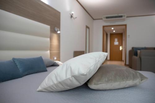 a bedroom with a bed with two pillows on it at Pegasus Hotel in Sassari