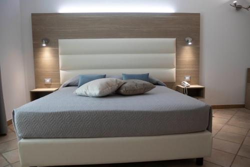 a bedroom with a large bed with two pillows on it at Pegasus Hotel in Sassari