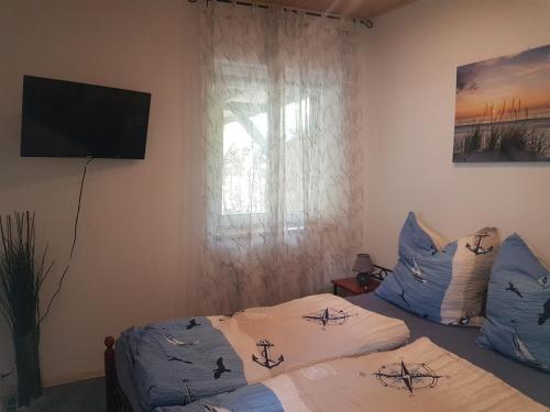 1 Schlafzimmer mit 2 Betten und einem Flachbild-TV in der Unterkunft Ferienhaus an den Moorwiesen in Bad Saarow