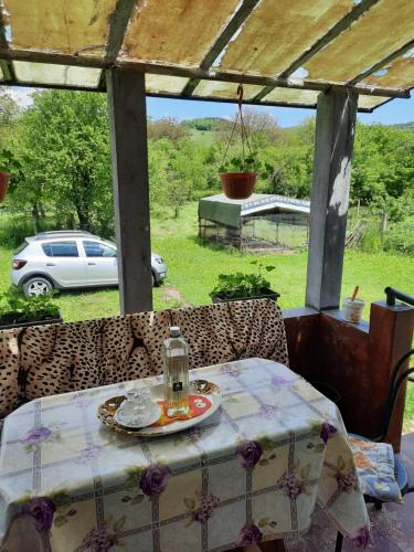 a table and chairs with a car parked in a yard at Vila la Izvorul Putinei in Haţeg
