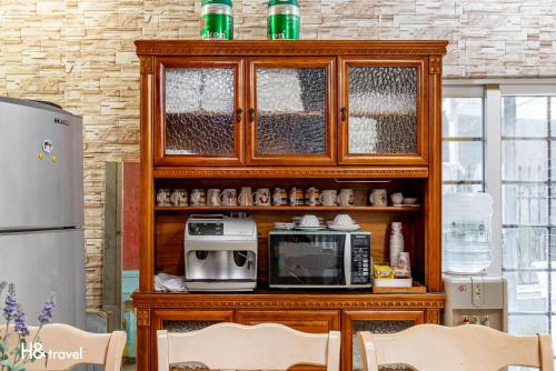 a kitchen with a wooden cabinet with a microwave at White Cotton Candy Homestay in Hualien City