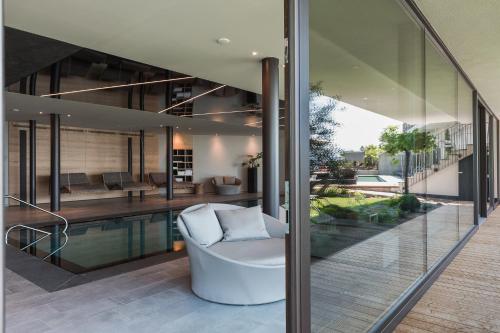a house with a swimming pool and a white couch at Lifestyle Hotel Alpin in Schenna
