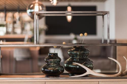 two vases sitting on a shelf in front of a mirror at Lifestyle Hotel Alpin in Schenna