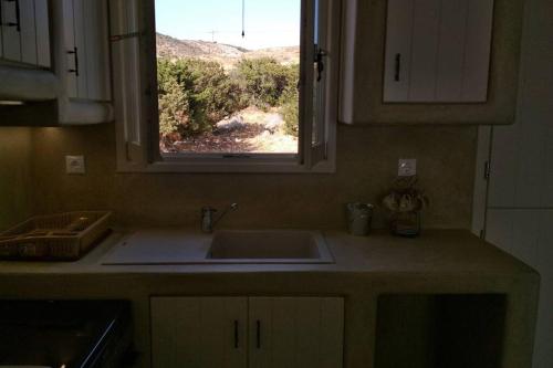 a kitchen counter with a sink and a window at Sarakiniko in Agiassos