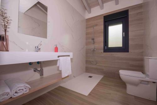 La salle de bains est pourvue d'un lavabo, de toilettes et d'une fenêtre. dans l'établissement adosadoduplex adaptado en zona de playa ideal familias, à Llanes