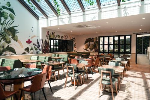a restaurant with tables and chairs in a room with windows at Eastern Sands City Centre in Geelong