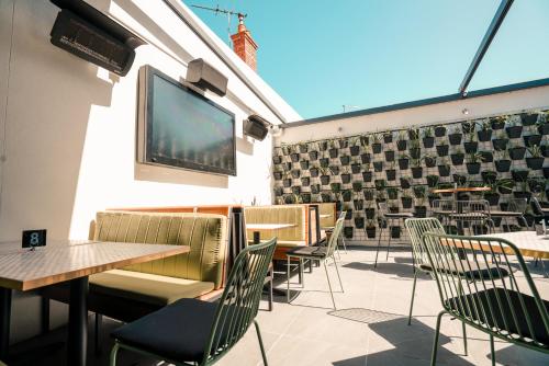 a patio with tables and chairs and a flat screen tv at Eastern Sands City Centre in Geelong