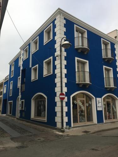 um edifício azul no lado de uma rua em DOMOBLU Camere In Centro em Tortolì