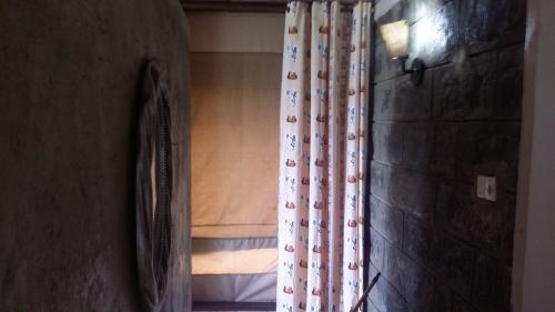 a room with a curtain and a bed with a window at Maili Saba Camp in Nakuru