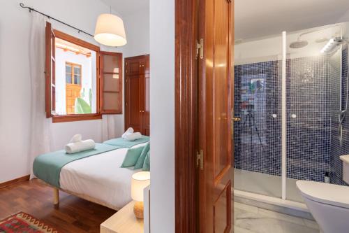 1 dormitorio con 1 cama y baño con ducha en Abades Giralda Deluxe by Valcambre, en Sevilla
