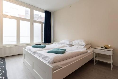 een groot wit bed in een kamer met een raam bij RedLight District Private Smokers Friendly Studio in Amsterdam