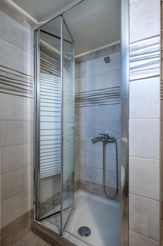 a shower with a glass door in a bathroom at Remezzo Aegean Mare Maisonette in Livadi Astypalaias