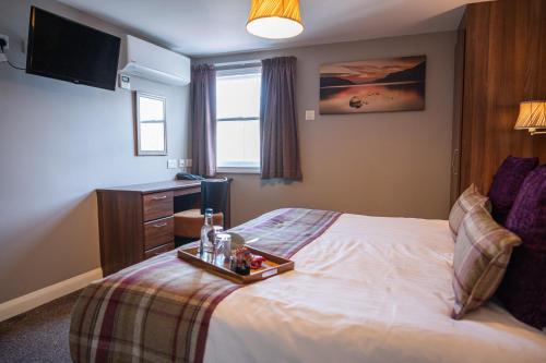 a hotel room with a bed with a tray on it at Foundry 34 in Penrith