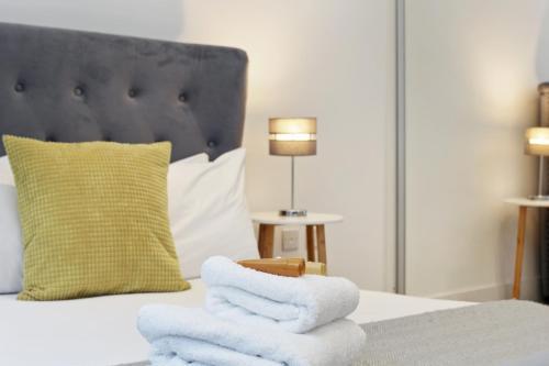 a pile of towels sitting on top of a bed at Lux 2 & 3 Bed Apartments in Camden Town FREE WIFI by City Stay Aparts London in London
