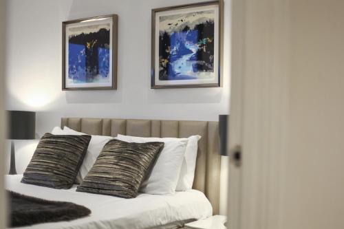 a bedroom with a bed with two pictures on the wall at Lux 2 & 3 Bed Apartments in Camden Town FREE WIFI by City Stay Aparts London in London