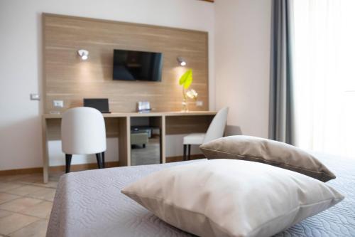 a bedroom with a desk and a bed with pillows at Pegasus Hotel in Sassari