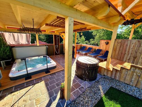 un patio con bañera de hidromasaje y pérgola de madera en Ferienhaus Winzerhaus Südsteiermark, en Leibnitz