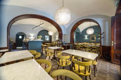 a restaurant with tables and yellow chairs and lights at Monsieur Miot Concept Hotel - Bastia centre in Bastia