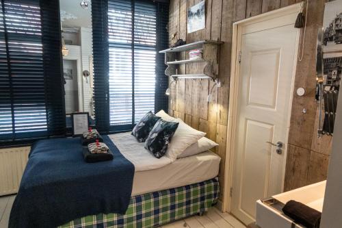 una camera con un letto con cuscini sopra di Guesthouseamsterdam ad Amsterdam