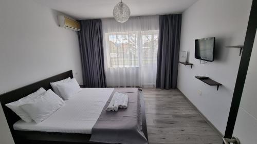 a bedroom with a bed and a television in it at Vila Albertino in Eforie Nord