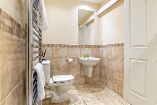 a bathroom with a toilet and a sink at Victoria Court Suites - Aberdeen in Aberdeen