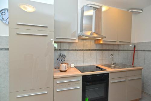 une cuisine avec des armoires blanches et un évier dans l'établissement Apartment Branko 2081, à Pula