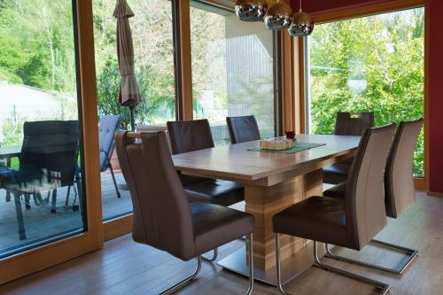 jadalnia z drewnianym stołem i krzesłami w obiekcie Appartement Elisa w mieście Hörbranz