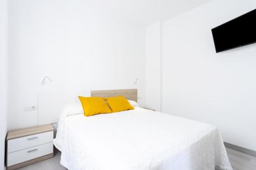 San Andrés的住宿－Home2Book Sea Front Las Teresitas Beach 4，白色卧室配有黄色枕头的床