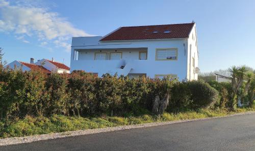a white house on the side of a road at Apartamentos na Quinta Altavista do Carvalhal in Zambujeira do Mar