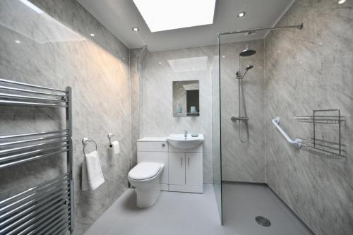 a bathroom with a shower and a toilet and a sink at Mews House in Ayr