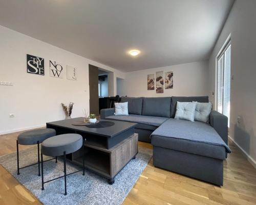 a living room with a blue couch and a table at Danubiana Apartments in Kladovo