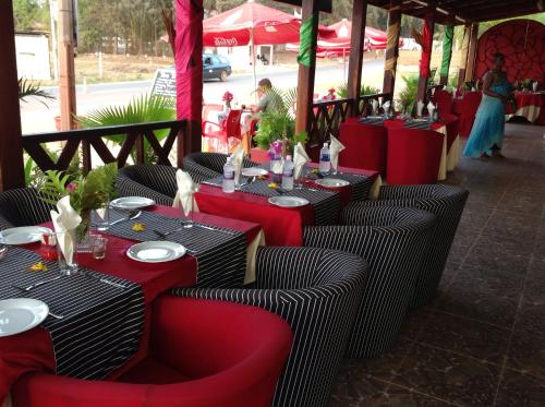 a restaurant with red and black tables and chairs at Calabash Apartment-Hotel in Kotu