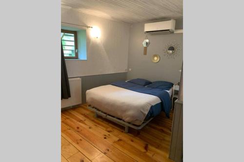 een slaapkamer met een bed met blauwe kussens bij Le gîte de la vallée du Douctouyre in Dun