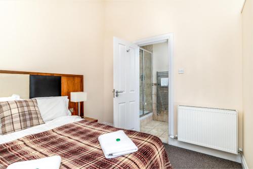 a bedroom with a bed with a laptop on it at Victoria Court Suites - Aberdeen in Aberdeen