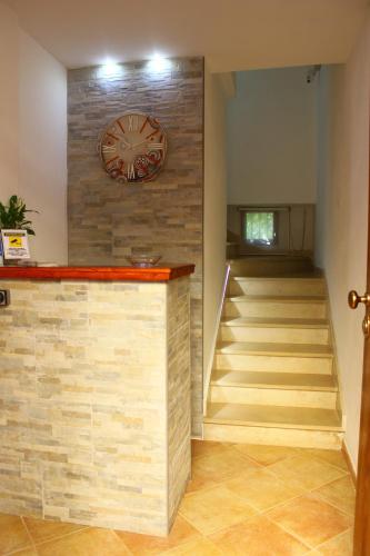 a lobby with a staircase and a clock on a wall at Del Cavaliere in Castrovillari