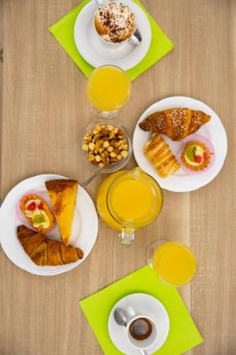 a table with plates of food and glasses of orange juice at Pegasus Hotel in Sassari